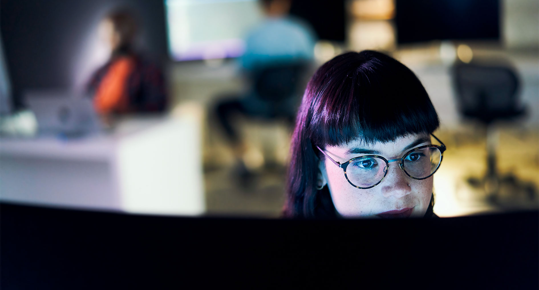 IT-Expertin analysiert Sicherheitsprozesse am Monitor.